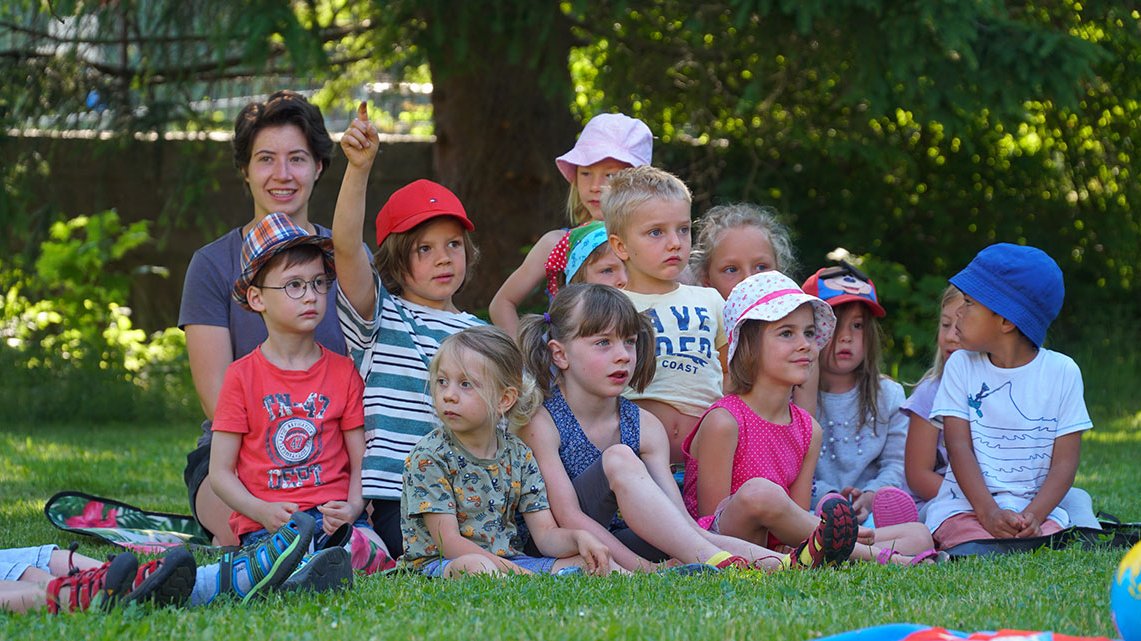 Kinder sitzt zusammen auf der Wiese