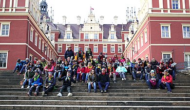 deutsche und polnische Schüler sitzen auf einer großen Treppe